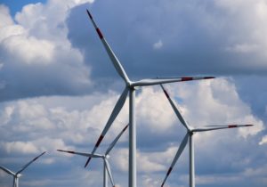 white and red wind turbine under blue sky during daytime