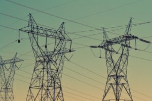 black transmission towers under green sky