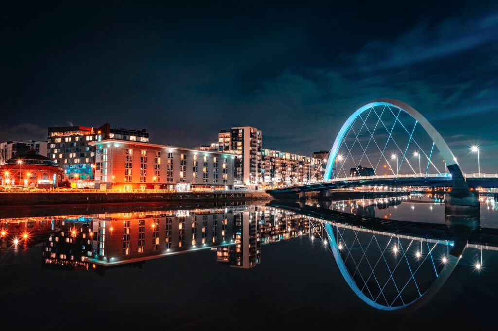 city skyline across body of water during night time