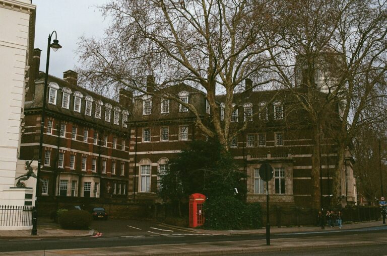 Red telephone box with buildings and trees